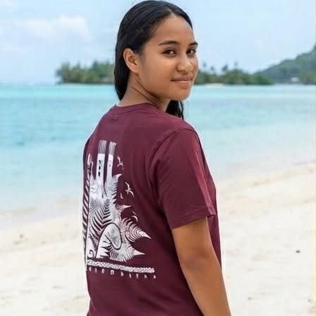 Jeune femme de dos en t-shirt bordeaux sur la plage